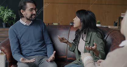 Angry husband and wife biracial couple fighting discussing family problems during session with therapist in office