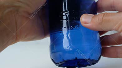 Person reads Braille. Braille font on a plastic water bottle. Accessibility for Persons with Disabilities.