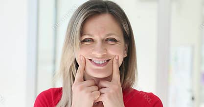 Woman pretends happiness by lifting lips with fingers