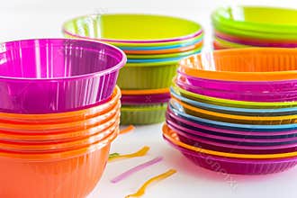 Brightly colored plastic kitchenware is stacked on table before the party