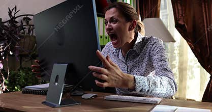 Mad female employee yells in monitor suffering from burnout