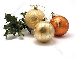 Three Christmas decorations and holly