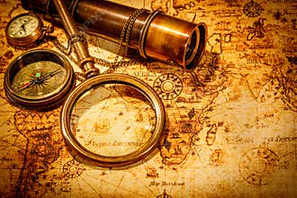 Vintage magnifying glass lies on an ancient world map