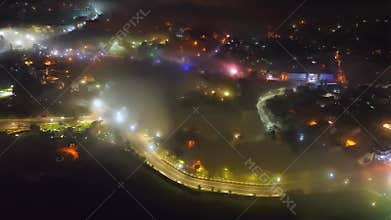 Aerial view of a Da Lat City in the mist magical night, hiden in the fog and clouds