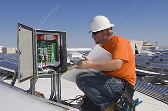 Electrical Engineer Holding Book While Analyzing Electricity Box