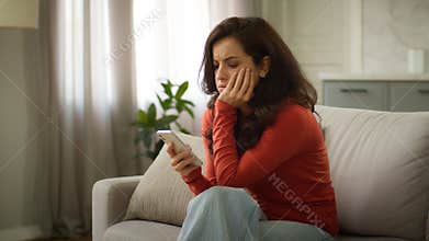 Shocked upset sad Caucasian troubled woman female girl client holding mobile phone cellphone reading bad news negative