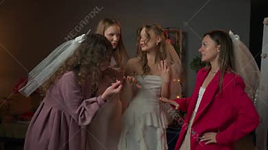 Group of young women friends and bride celebrating bachelorette party at home, girls and bride looking talking about