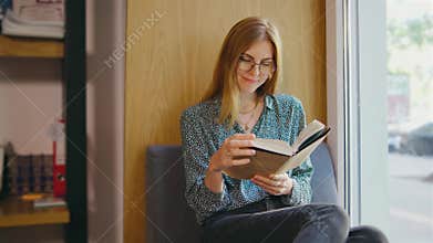 Young woman student or businesswoman reading a book in the library. Students in a good mood studying and reading books