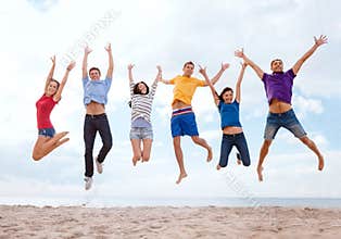 Group of friends jumping on the beach