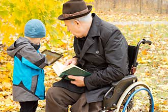 Young boy showing his grandfather his tablet