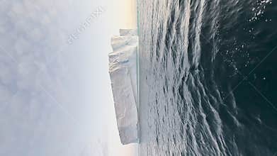 A huge high breakaway glacier is passing by in the southern ocean off the coast of Antarctica, the Antarctic Peninsula