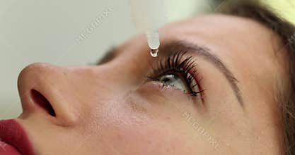 Closeup of a woman applying eye drops to eye