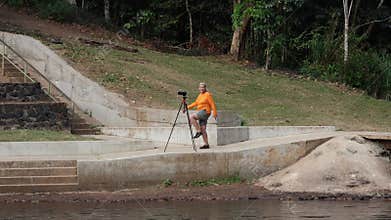 A woman photographer doing exercises while waiting for a photograph