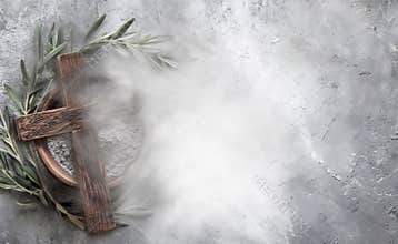 Ash Wednesday concept with ashes, cross and olive leaves on concrete stone background