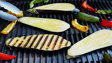Turn over eggplant with vegetables grill on a cast iron barbecue. Close up. Slow motion