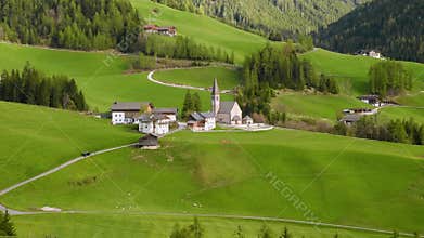 Santa Magdalena village with church in Dolomites mountains, Val Di Funes, Trentino Alto Adige, Italy. Alpine meadow in