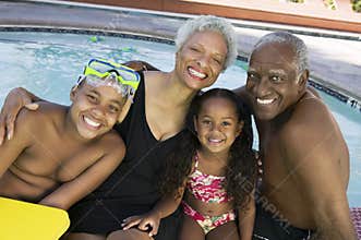 Portrait Of Grandchildren With Grandparents By Swimming Pool