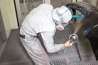 Car body painter spraying paint on bodywork parts