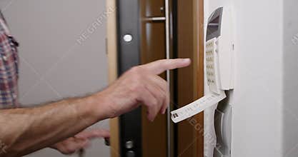 Man setting alarm system at home during the night