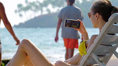 Woman films on mobile phone tropical paysage on sunny day