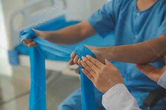 Physical therapist guiding patient with resistance band