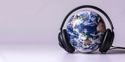 Headphones on a globe, Music without borders, concept for World Music Day, banner, copy space