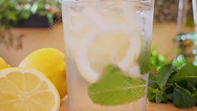 Soft Drink with Ice, Bubbles, Mint and lemon in glass. Outdoors