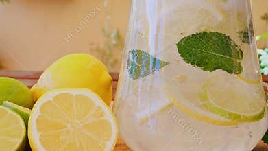 Soft Drink with Ice, Bubbles, Mint, lemon, lime in a glass decanter. Outdoors