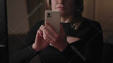 In a contemporary office setting at nighttime, a lady is seen using her smartphone for browsing