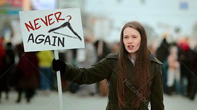 Legal abortion protest. Woman hold banner with never again slogan. Hanger symbol