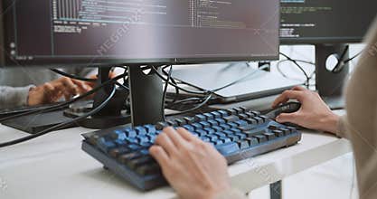 Asian male, female software developer coding program on desktop computer. Man, woman work from home