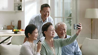 two senior asian couples taking a selfie using cellphone happy and smiling