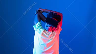 African sport player wearing VR stretching arm neon light wall. Contrivance.