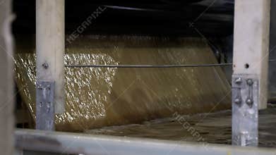 Brown liquid cellulose poured into reservoir in workshop