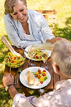 Senior couple having picnic in the garden