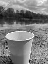 paper cup on the background of the bank of the Berezina River in summer