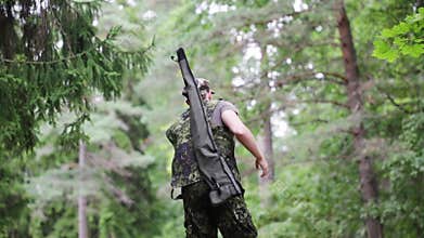 Young soldier or hunter with gun in forest