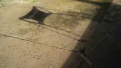 Shadow of unrecognizable boy child jumping from swing seat in summer afternoon.
