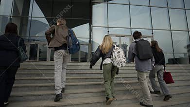 Students and Professor Ascending Stairs Towards a Modern University Building