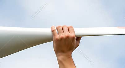A hand gripping a white railing with a blue sky background