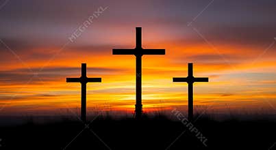 Three crosses on a hill at sunset with vibrant orange sky