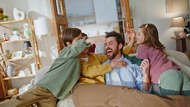 Blindfold cheerful man playing game with family closeup. Father catching mother