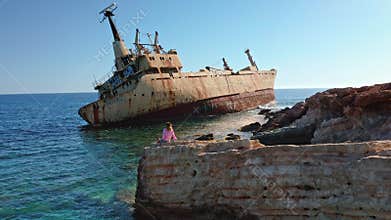 Young woman observing EDRO III shipwreck in Paphos, Cyprus