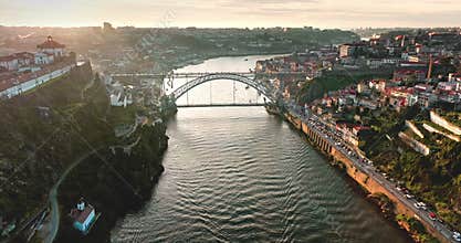 Douro river flowing through Porto cityscape at sunset