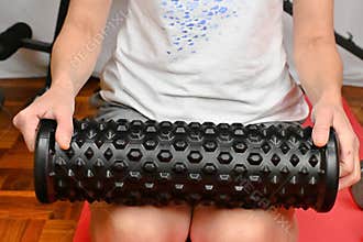 Woman doing self-massage of her legs after a home workout