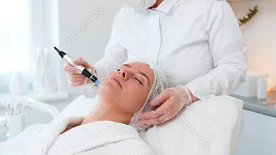 Cosmetologist doing peeling procedure, woman skin regeneration, dermapen microneedling, dermastamp