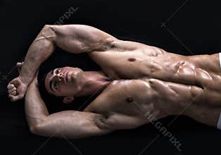 Attractive young man on the floor with muscular ripped body