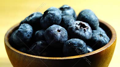 Closeup ripe sweet blueberry fruits in wooden bowl.
