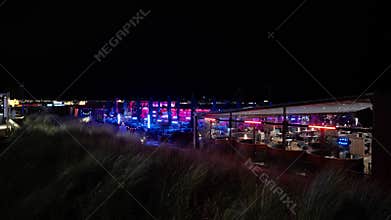 SCHEVENINGEN, NETHERLANDS - SEPTEMBER 14, 2025 - Vibrant Scheveningen beach restaurants illuminated at night