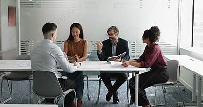 Diverse business team talking at meeting table, brainstorming on ideas